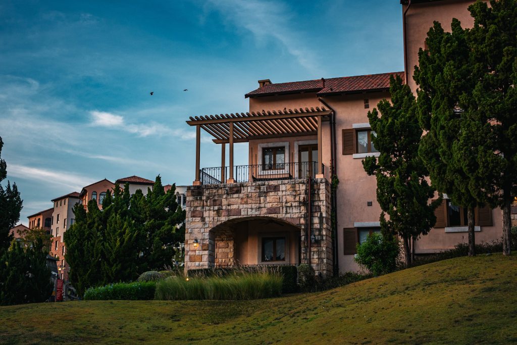 Charming rustic house with Tuscan-style architecture surrounded by lush greenery in Thailand's scenic outdoors.
